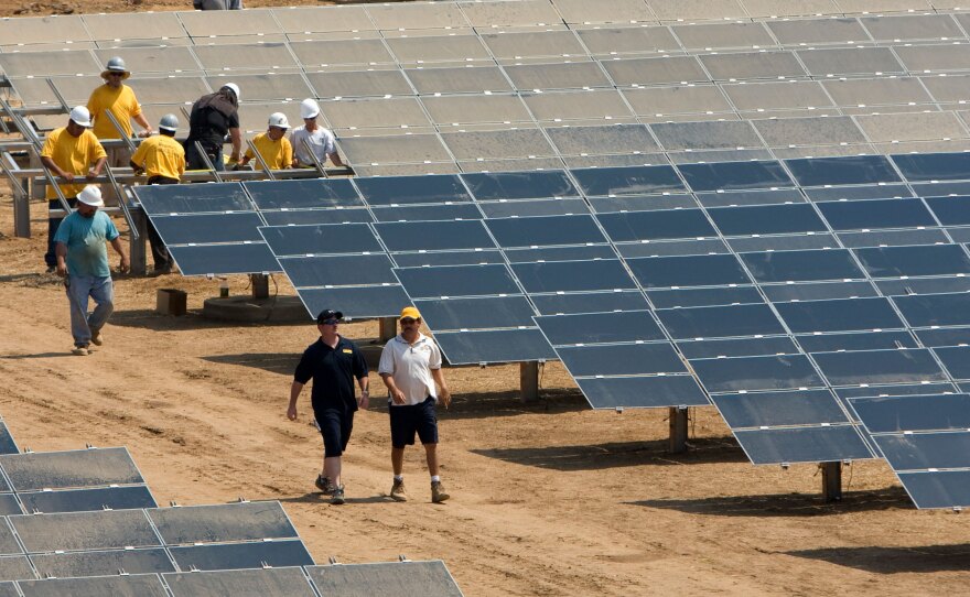 Workers install a solar farm outside Sacramento, Calif. The state aims to attain half of its electricity from renewable sources by 2030.