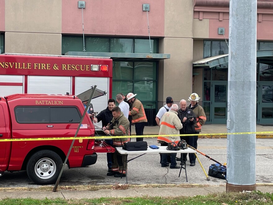 Evansville firefighters work at a command post outside the scene of the crash and collapse