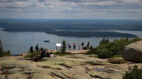 Tourists on the summit of Cadillac Mountain, in Acadia National Park. Signs direct visitors to stay on the path, to avoid trampling sensitive mountain flora.