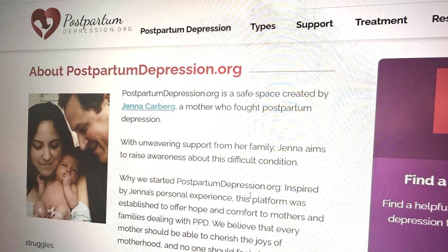 closeup of a webpage with text on postpartum depression and a photo showing a mom, dad and baby 