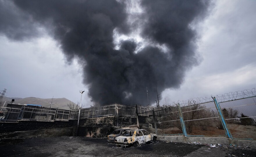 FILE - A thick plume of smoke rises from an oil storage facility hit by a U.S.-Israeli strike in Tehran, Iran, March 8, 2026. 