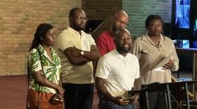 Five Haitians standing around a podium in a church. Haitian members of Organizing Undivided thank the Miami Valley community for publicly supporting Haitian immigrants.