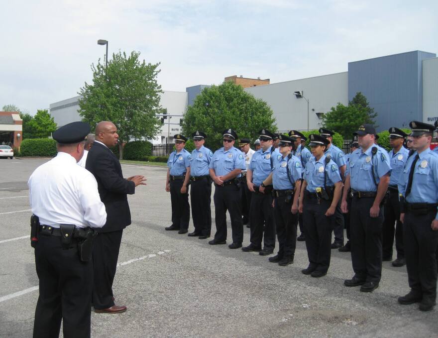 Sam Dotson and officers listen to James Clark before a hotspot patrol in the Wells-Goodfellow neighborhood.