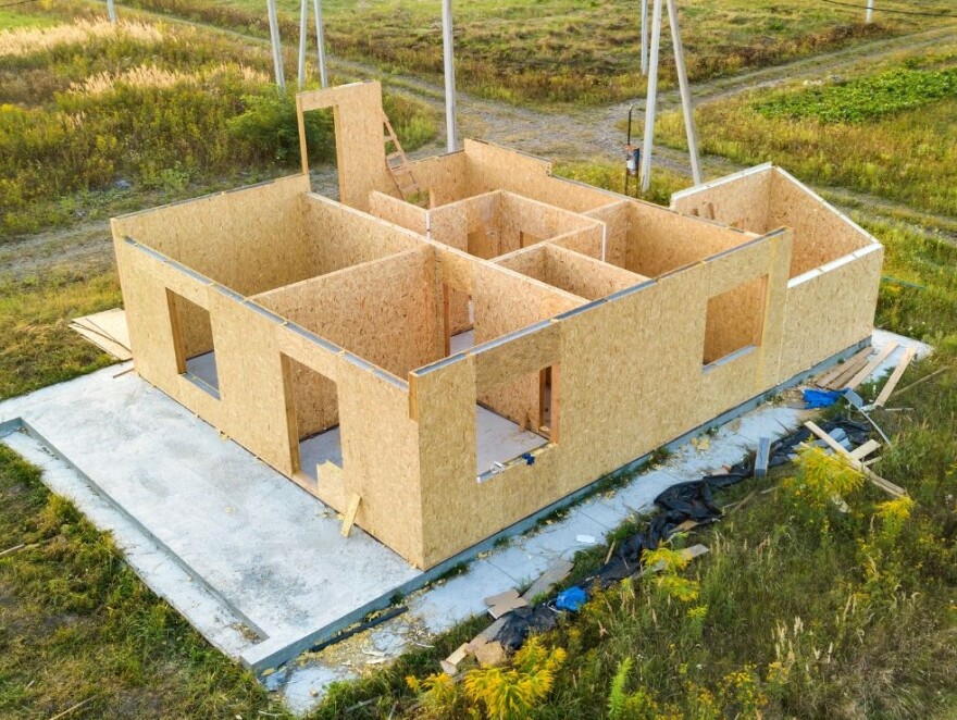 Partially built house with wooden walls erected in a field