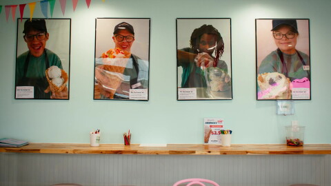 pictures of kids scooping ice cream on a wall in an ice cream shop