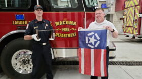 Lt. Ethan Taylor (left) holds the remnant from the World Trade Center, while Chief Dan Meyer displays the Freedom Flag.