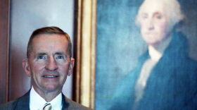 Colour portrait of Ross Perot posing in his office with George Washington painting