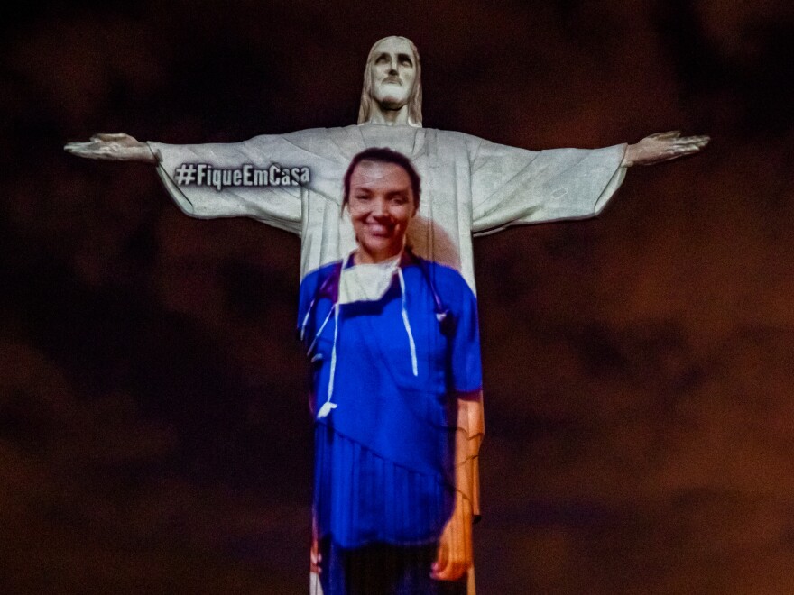 A medical worker's image is projected onto Christ the Redeemer in Rio de Janeiro, Brazil. The country is one of 14 nations that has confirmed at least 20,000 coronavirus cases.