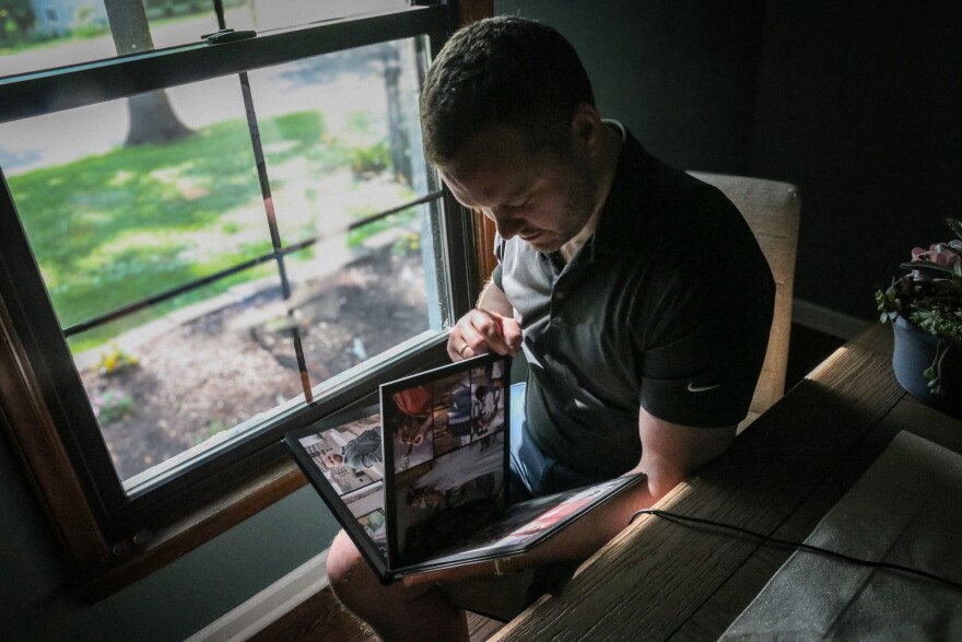 Clayton Anderson flips through his wedding album in his Leawood home.