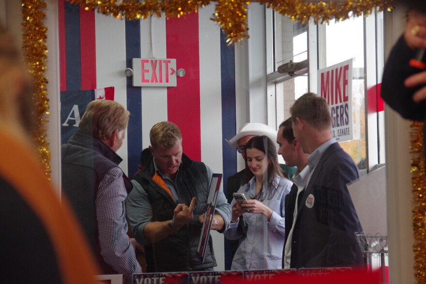 United States Senator Tim Sheehy (R-MT) (center left) holds a middle finger to a campaign sign that reads "Abdul is an Idiot". Next to him, Republican Senate nominee Mike Rogers (left) laughs with his back turned. Sheehy campaigned for Rogers at an event in St. Joseph, Michigan at the Berrien County GOP offices on Thursday, October 29.