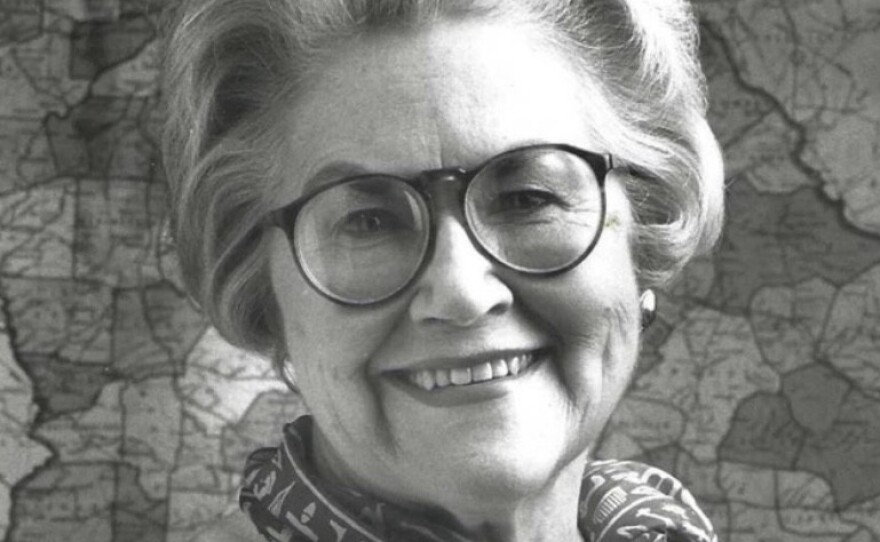 black and white portrait of a lady with glasses.