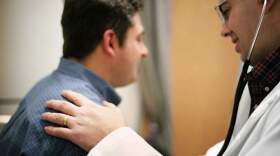A doctor uses a stethoscope on a patient. (AstraZeneca/AP)