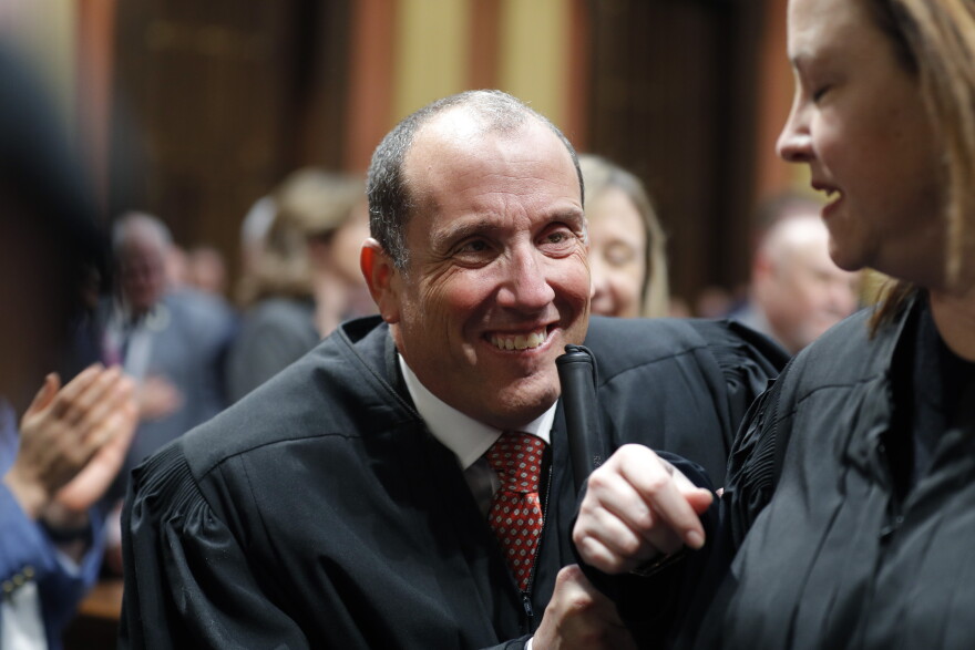 FILE - Michigan Supreme Court Justice Richard Bernstein is escorted to his seat before the State of the State address on Jan. 25, 2023, at the state Capitol in Lansing, Mich. Bernstein announced Tuesday, April 18, that he is getting mental-health treatment outside the state and will not hear a case next week. (AP Photo/Al Goldis, File)