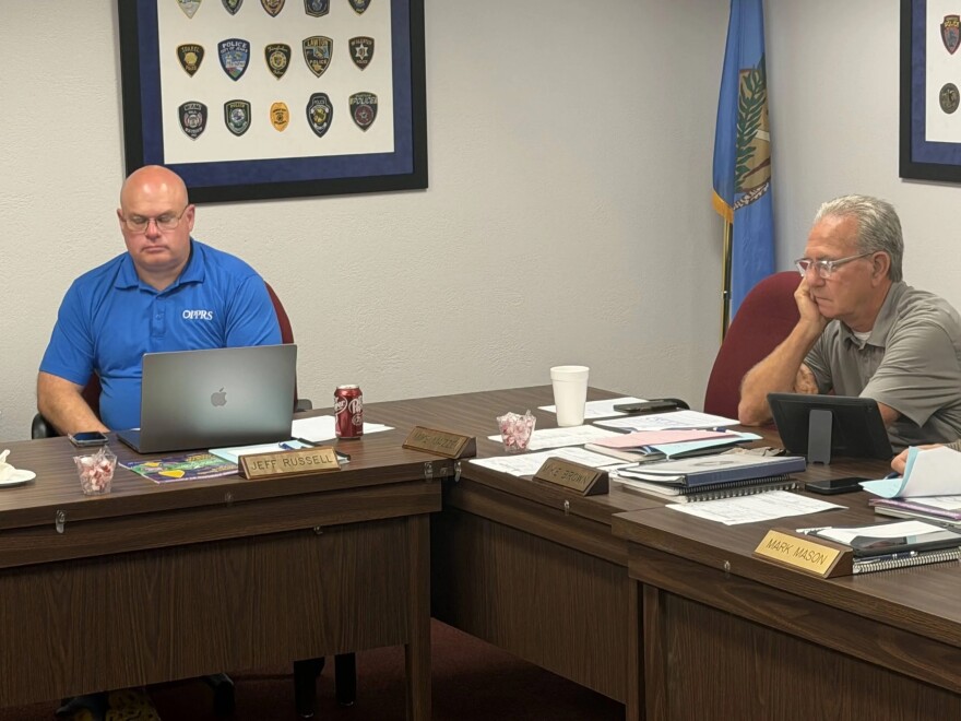 Jeff Russell and Mike Brown, two of the board members of the Oklahoma Police Pension and Retirement System, listen during a meeting on Wednesday, July 15, 2026, in Oklahoma City. In between them is an empty place for fellow OPPRS board member and GOP gubernatorial candidate Mike Mazzei.