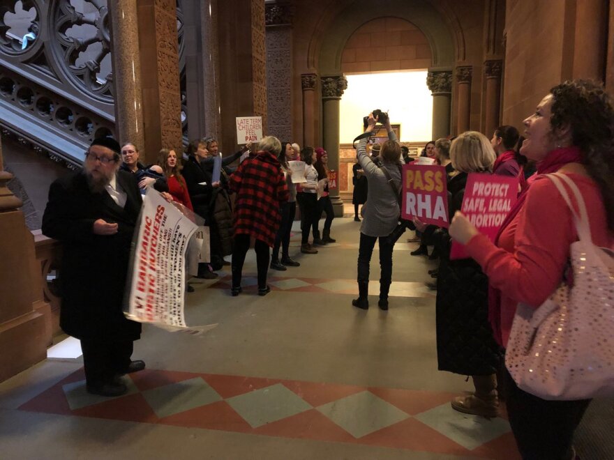 Pro- and anti-Reproductive Health Act protesters chant outside the New York state Senate chamber with voting on the measure underway.  