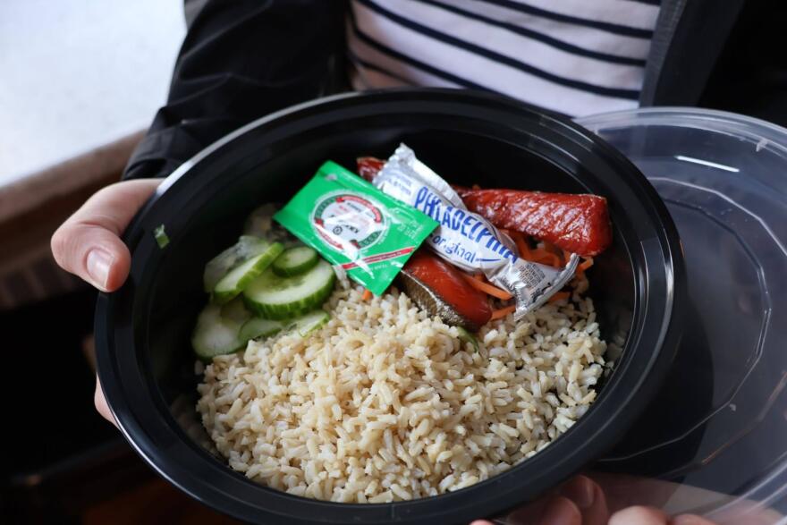 a bowl with salmon, cucumber, carrots, rice, soy sauce and cream cheese