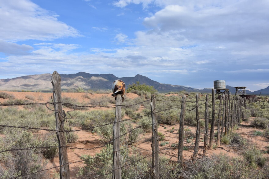 A barbed wire fence at Trinity Base Camp. A water tower is seen in the distance. (Courtesy Jeff Rice)