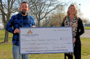 Camp Quality's Executive Director Eddie Bobbitt (left) and Vice President of Community Philanthropy at CFSI Crystal Gunther (right) holding a check for the Community Assist Grant