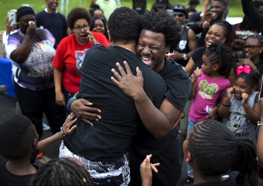 Mike Hassell, of the Chosen for Change foundation, hugs Joshua Anderson, of the Get Fit Crew, after a dance-off at a party to celebrate what would’ve been Mike Brown’s 20th birthday on May 20, 2016 at Canfield Green Apartments.