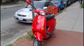 <strong>All Locked Up:</strong> This Vespa is on the sidewalk, away from road trouble. A solid chain helps deter thieves, though it should be secured to something more substantial than a traffic sign.