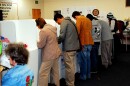 People lined up at voting booths.  