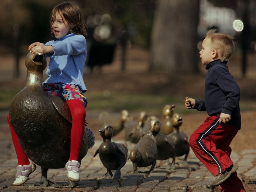 Brianna Henderson and her brother Ian Henderson play on the <em>Make Way for Ducklings</em> statues in Boston. The bronze figures by sculptor Nancy Schon were installed in Boston's Public Garden in 1987.