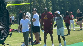 Washington Commanders owners Josh Harris, front left and Magic Johnson, second from right, attend an NFL football practice in Ashburn, Va., Wednesday, Sept. 6, 2023. (AP Photo/Stephen Whyno)