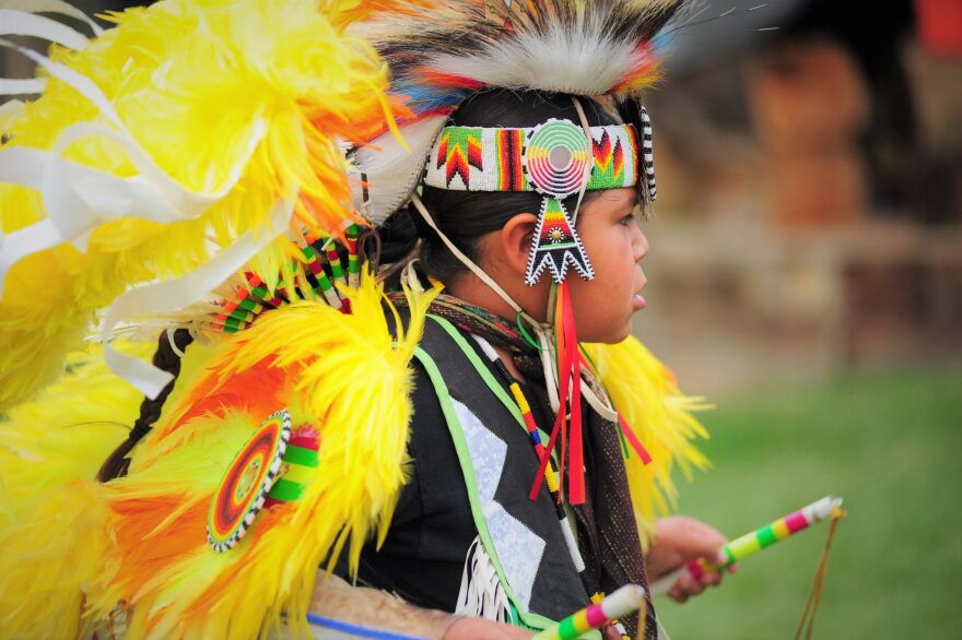 Native child in traditional regalia at Wind River powwow.
