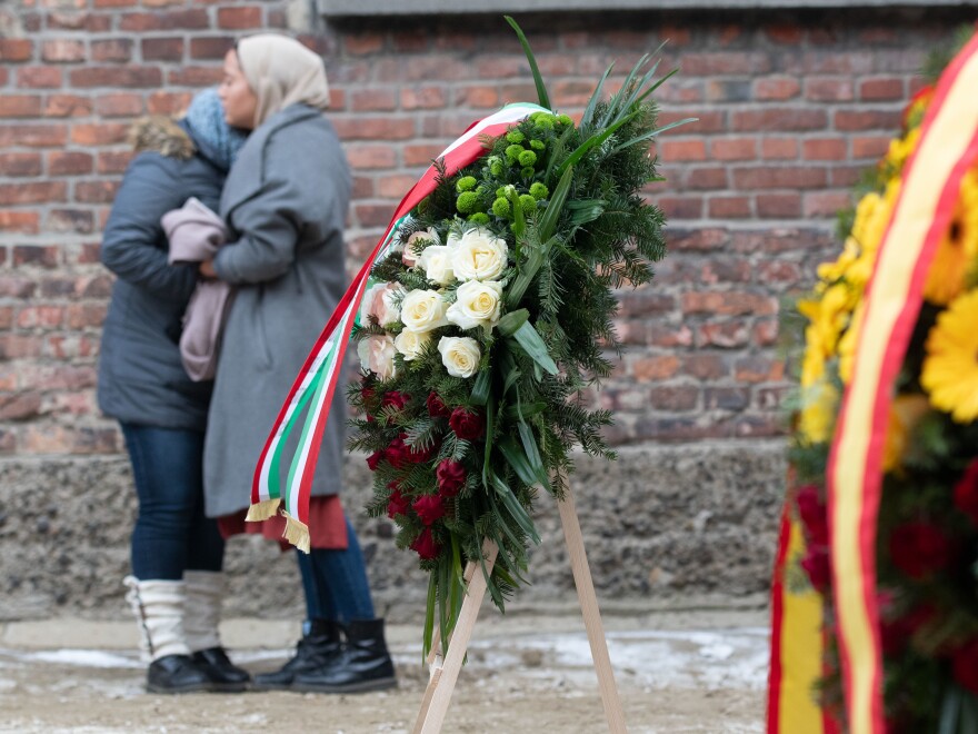 Two people mourn at the former concentration camp Auschwitz.