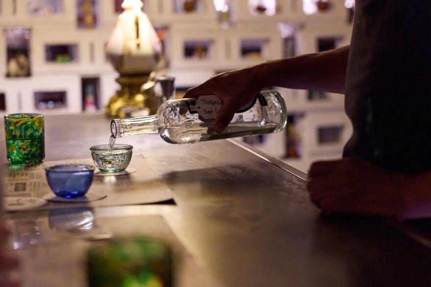 A waiter serves a glass of mezcal at In Situ distillery in Oaxaca City, Mexico, Friday, Jan. 23, 2026. 