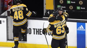 Boston Bruins' Patrice Bergeron (37) hugs Brad Marchand (63) as Matt Grzelcyk (48) walks off the ice after losing to the Florida Panthers in overtime during Game 7 of an NHL hockey Stanley Cup first-round playoff series. (Michael Dwyer/AP)