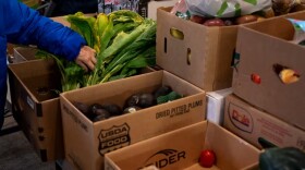 FILE - A person picks out greens at One Life Food Pantry, located in Real Life Foursquare Church in Vancouver, Wash., on Nov. 1, 2025.