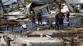 People stand on the destroyed bridge to Pine Island as they view the damage in the aftermath of Hurricane Ian in Matlacha, Fla., Sunday, Oct. 2, 2022. The only bridge to the island is heavily damaged so it can only be reached by boat or air. (AP Photo/Gerald Herbert)