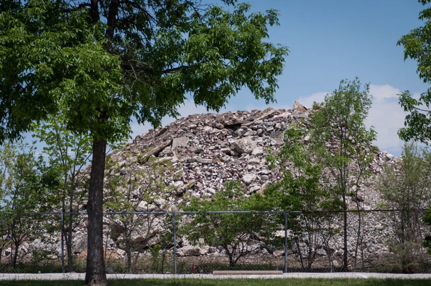 Parents and staff blame illnesses inside the Gateway school complex on debris brought over from the site of the planned National Geospatial-Intelligence Agency headquarters. The piles tower over a fence next to the school. May 6, 2018.