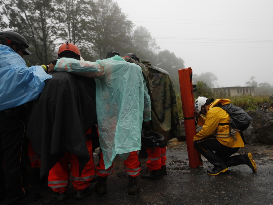 Volunteer firefighters huddle in prayer before beginning a search and rescue operation in San Cristobal Verapaz, Guatemala, Nov. 7, in the aftermath of Hurricane Eta.