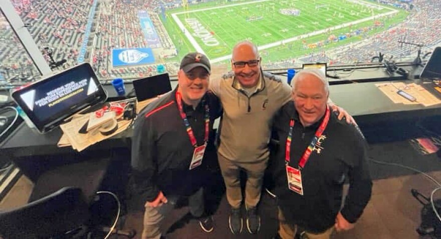 Broadcasters Mo Egger (left) and Dan Hoard (center) in the radio booth with Jim Kelly.