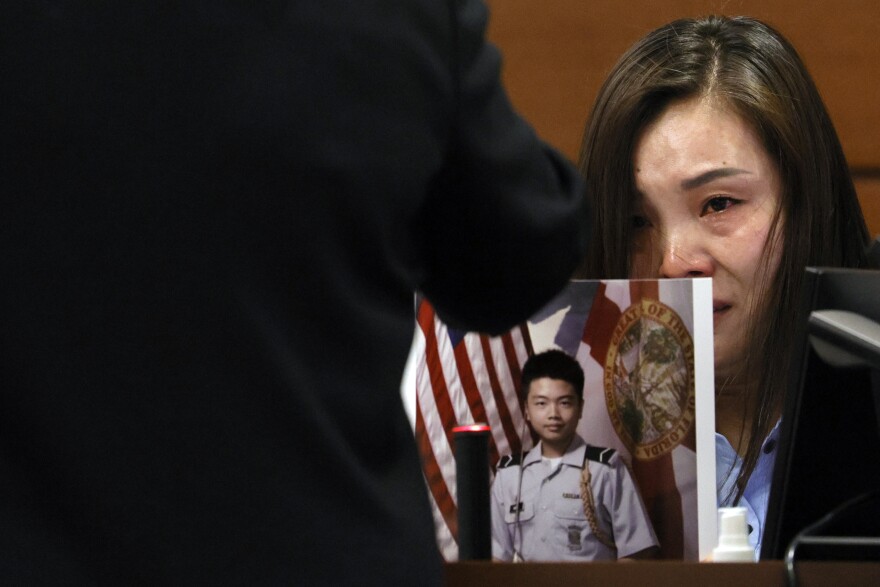 Hui Wang becomes emotional as she is asked to hold a photograph of her son, Peter Wang, during victim impact statements in the penalty phase of the trial of Marjory Stoneman Douglas High School shooter at the Broward County Courthouse on Aug. 4, 2022. Peter Wang was killed in the 2018 shootings.