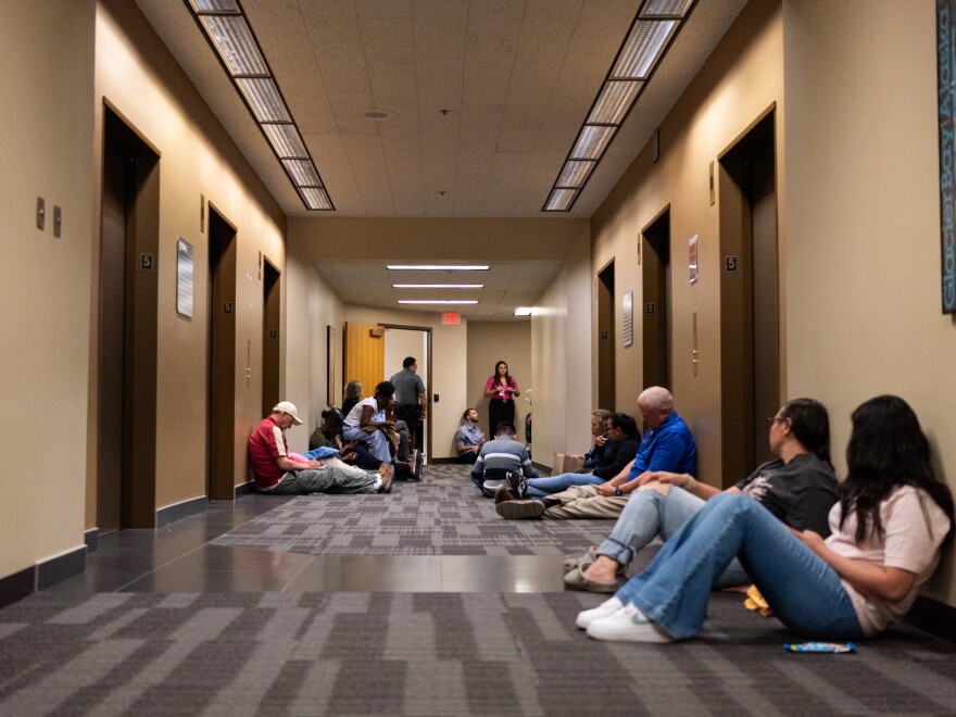 People, including minors, wait outside an immigration courtroom Thursday, July 9, at the Henry M. Jackson Federal Building in Seattle. The courtroom this week began so-called "mega master" hearings that speed up immigration hearings for youth pursuing legal status in the U.S.