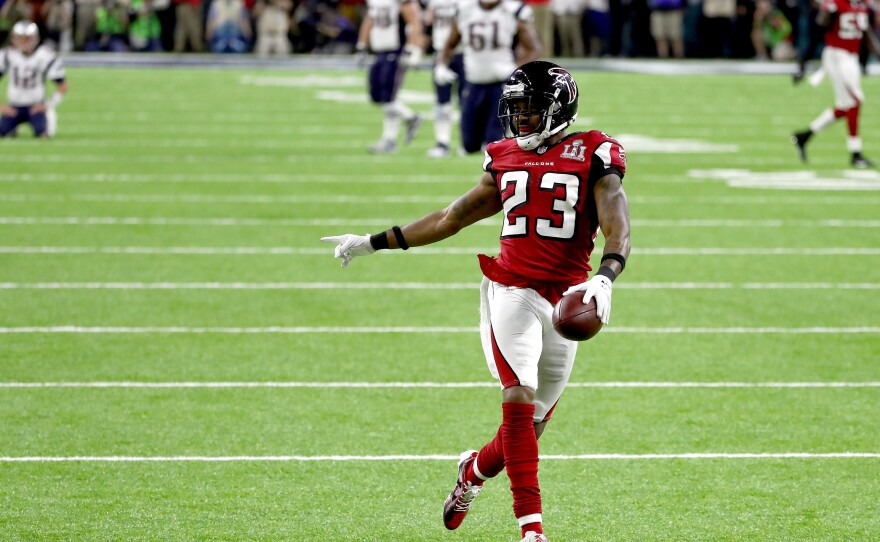 Falcons defensive back Robert Alford scores an 82-yard touchdown after picking off a pass by Patriots quarterback Tom Brady. The score gave the Falcons a daunting lead.