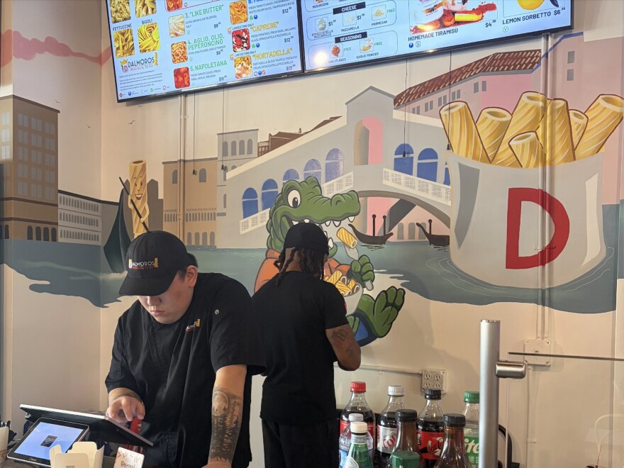 General manager Jackson Zheng, 26, (left) readjusts register numbers. Employee Zach Taylor, 31, (right) cleans equipment over the trash can on March 5.