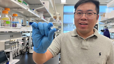 Researcher Penghui Zhao holds up a wearable medical device that can prevent accidental opioid overdoses.