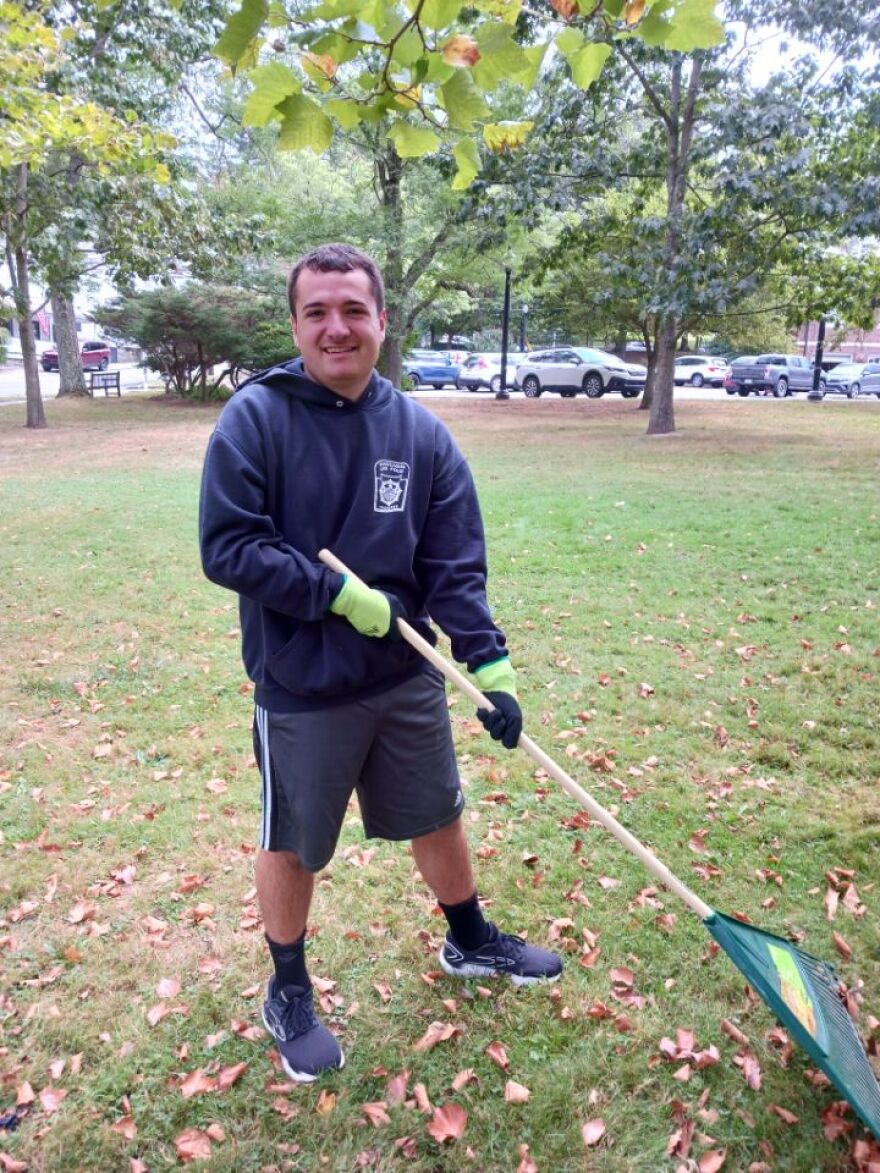 Hunter Polishan rakes leaves as he volunteers in his community.