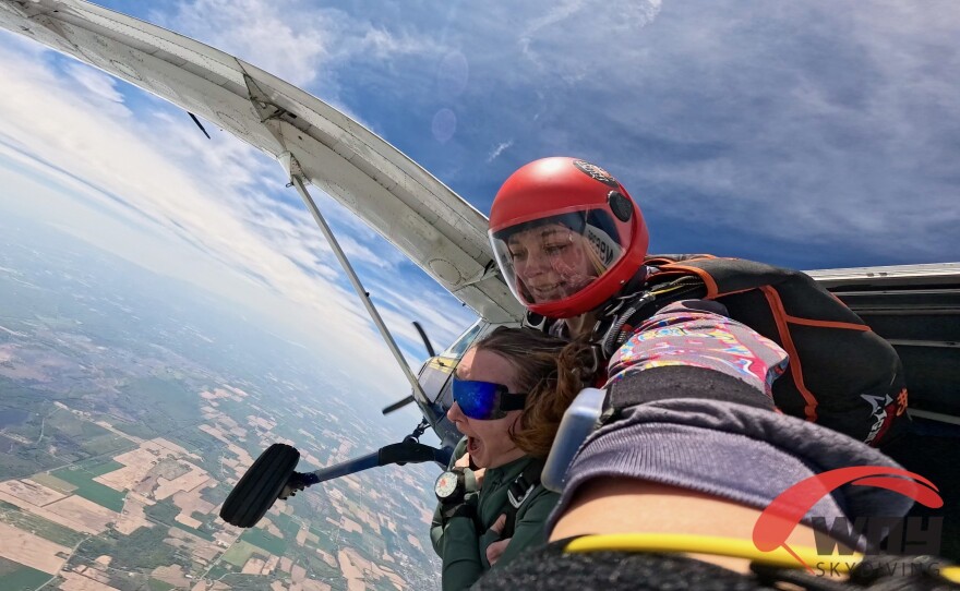 A woman prepares to jump out of a plane.