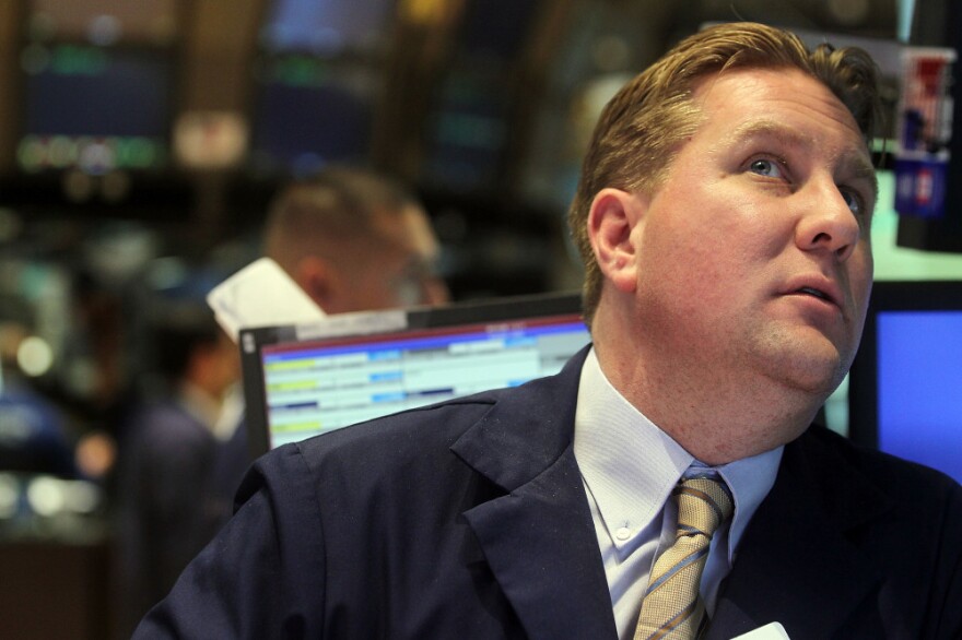 A trader at the New York Stock Exchange watches a monitor moments before the Federal Reserve announced it would keep interest rates low through at least 2013. The news reassured investors and helped sustain a rally.