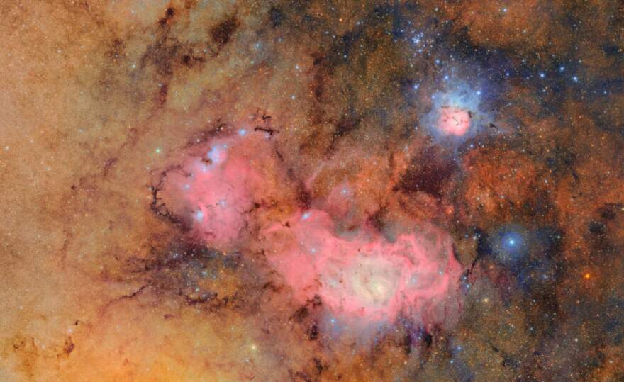 This image provided by the NSF-DOE Vera C. Rubin Observatory shows 678 separate images taken by the observatory in just over seven hours of observing time. Combining many images in this way clearly reveals otherwise faint or invisible details, such as the clouds of gas and dust that comprise the Trifid nebula (top right) and the Lagoon nebula, which are several thousand light-years away from Earth. (NSF-DOE Vera C. Rubin Observatory via AP)