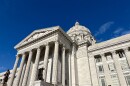 The columns at the entrance of the Missouri state capitol building. Some statues and sculptures are visible. 
