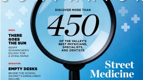 The August magazine cover, with a person holding a microscope