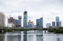 Skyscrapers are pictured under construction on the other side of a bridge spanning a waterway