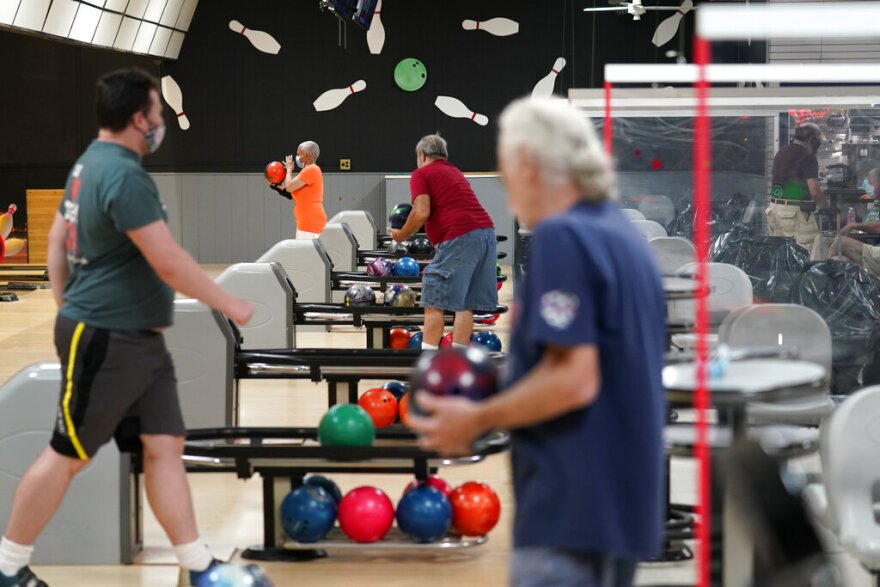 People separated by plexiglass barriers bowl at Homefield Bowl in Yonkers, N.Y., in August.