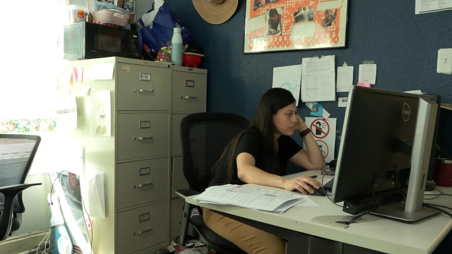 Paloma Ramos, a benefits coordinator at Casa Marianella's benefits clinic, works at her computer on Feb. 27. She said that since the increase in immigration enforcement across the U.S. and in Texas, the clinic has seen a decline in clients.